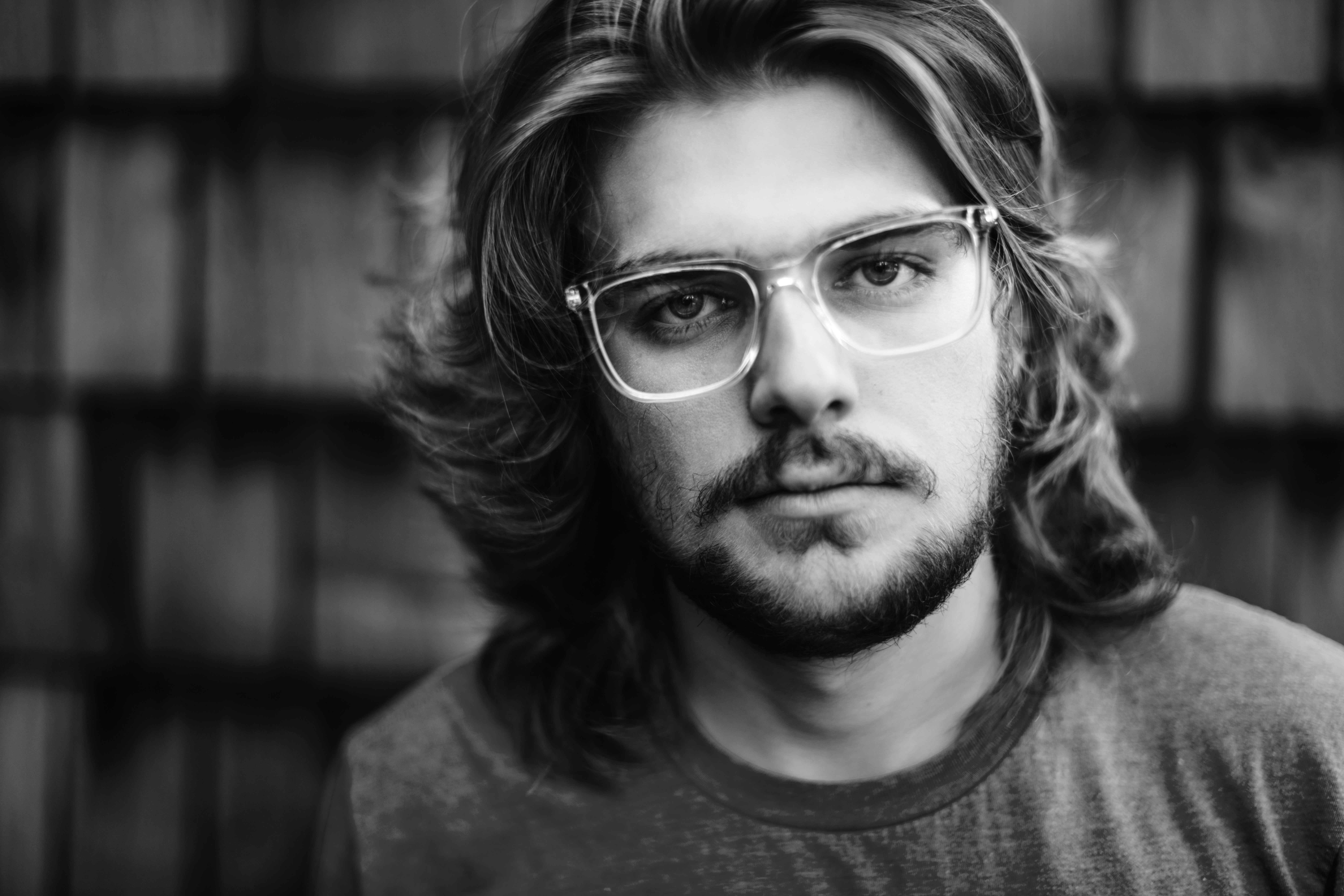 man in crew neck shirt wearing eyeglasses in grayscale photography